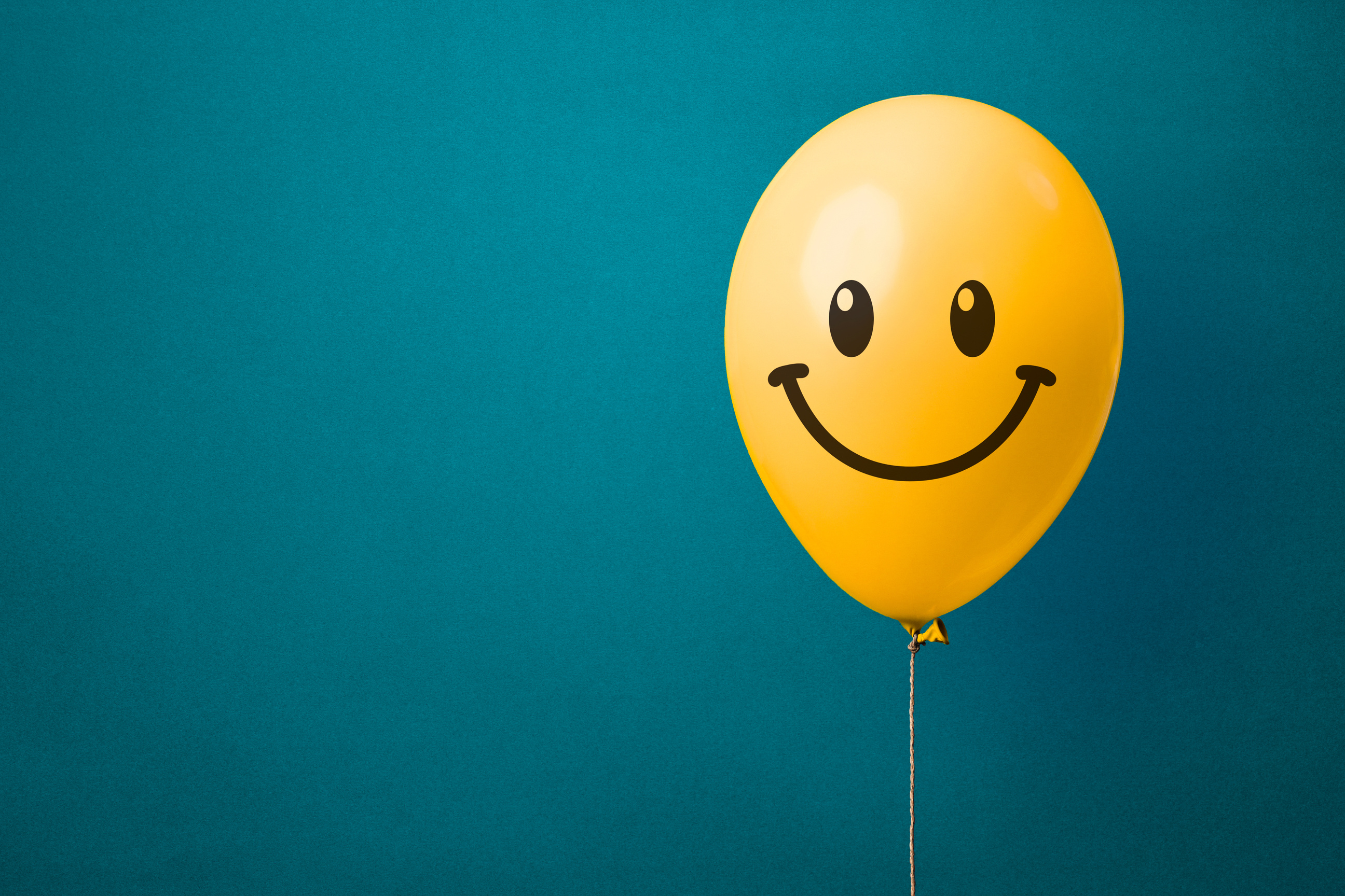 Yellow Balloon with Happy Face on a Blue Background